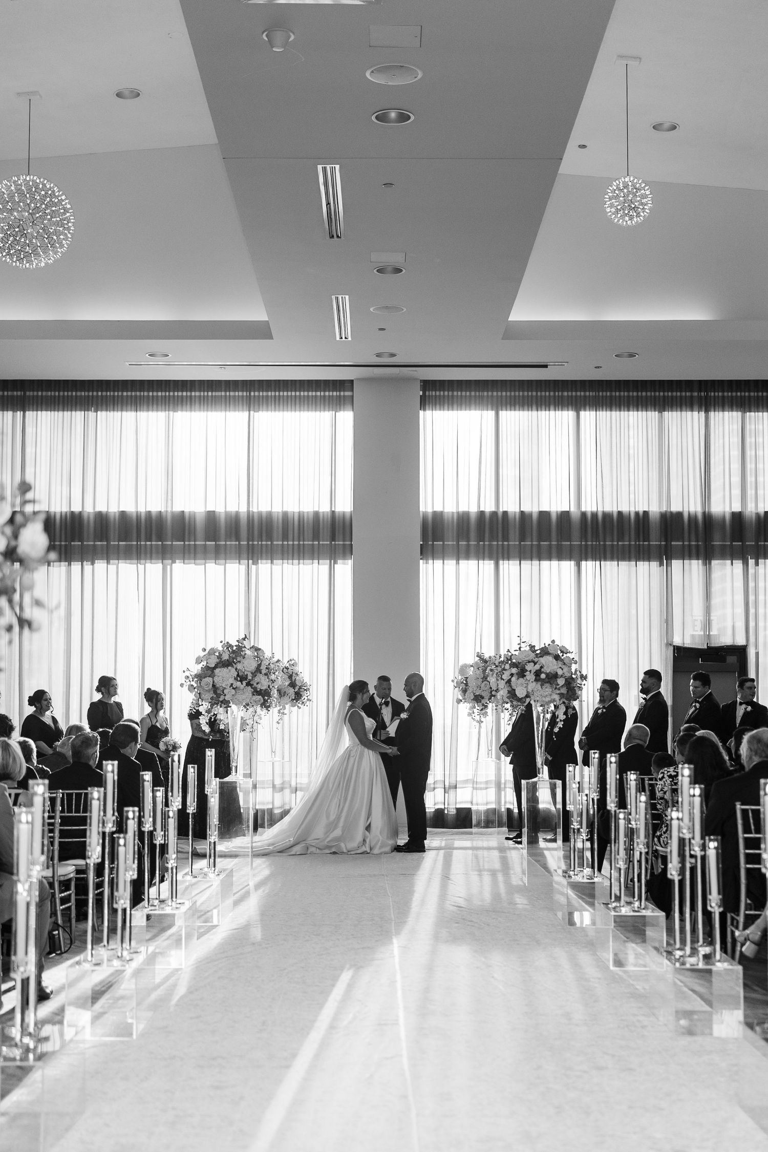 A couple walks together on a curved stone path outside a brick mansion venue with an awning entrance.