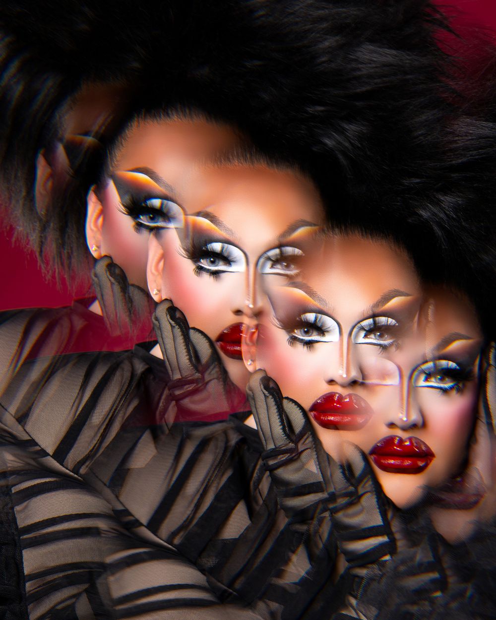 A dramatic artistic portrait with bold red lips, smoky eye makeup, and dark hair against a shadowy background.