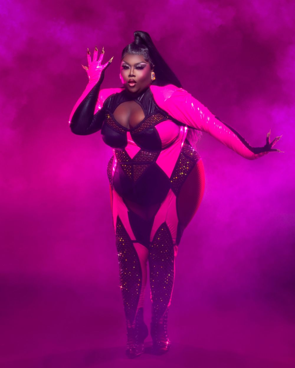 Performer in a sparkly black costume strikes dramatic poses under vibrant pink and purple stage lighting.