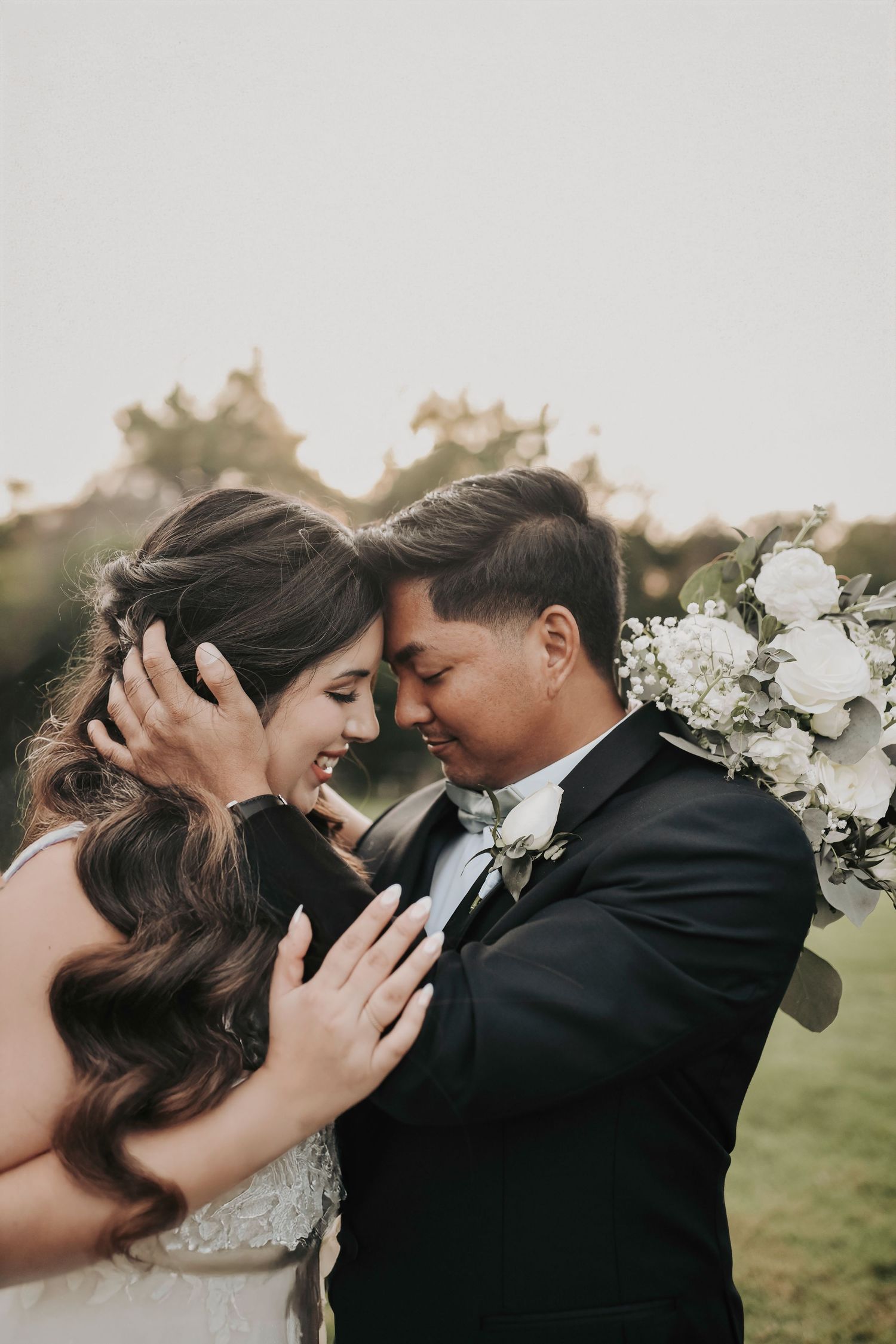 Bride and groom embracing during sunset wedding photos