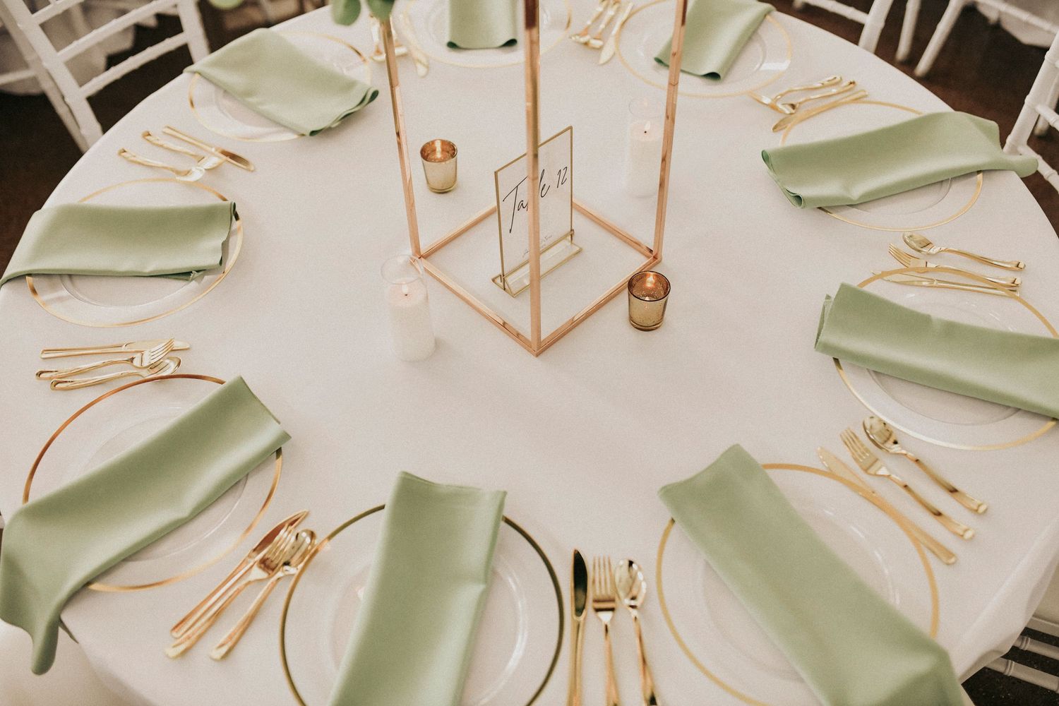 Reception tables styled with ivory linens and gold flatware at Firefly Gardens