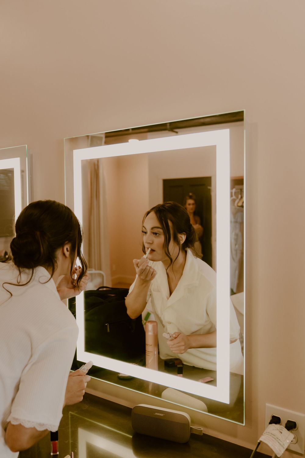 Getting ready moments captured in mirrors showing wedding day preparations.