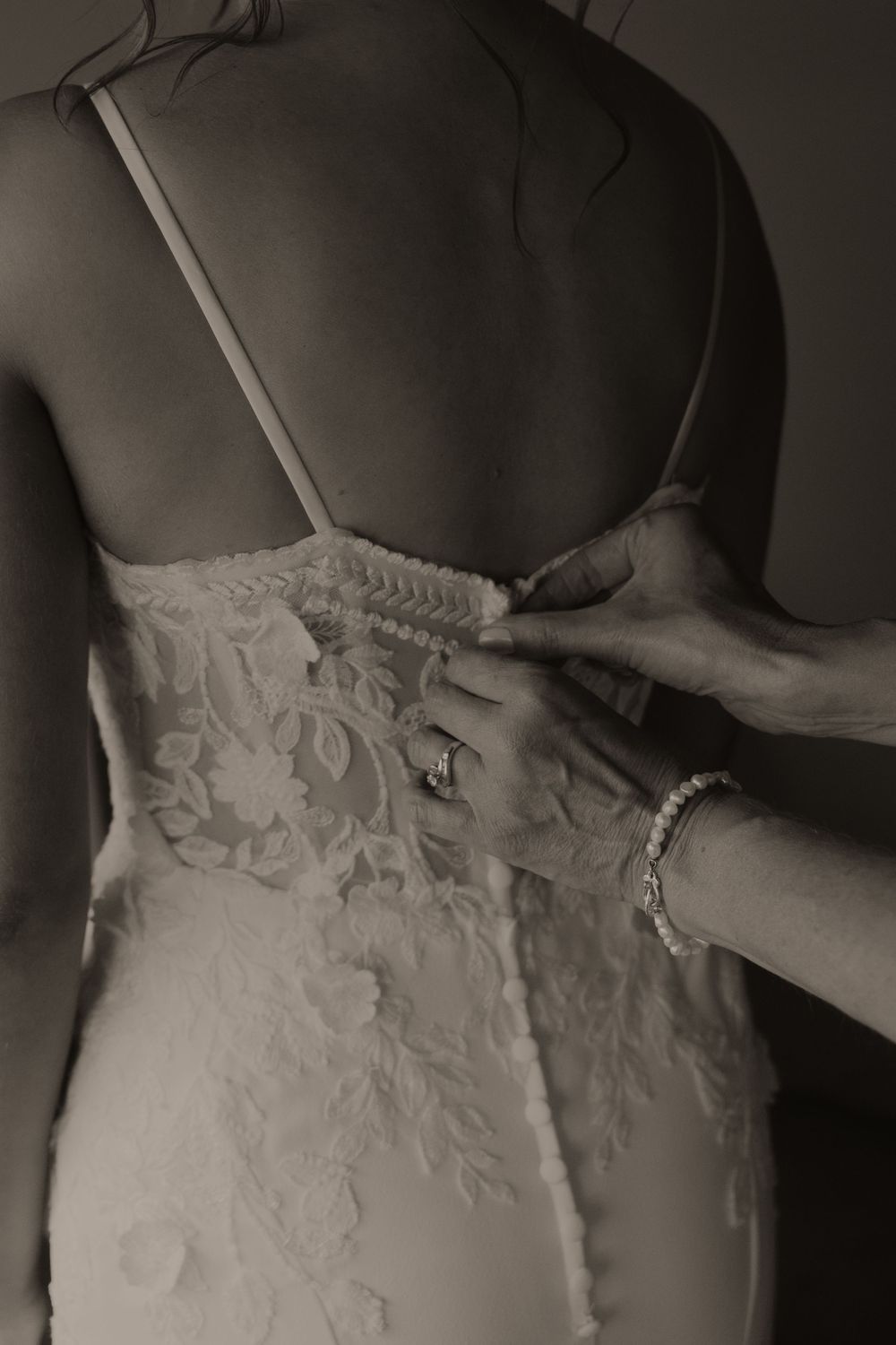 Close-up view of delicate white floral lace details on a wedding dress bodice.