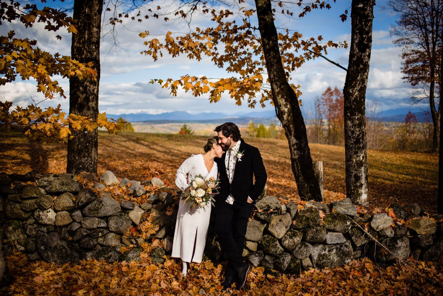wedding couple sharing an embrace in the Vermont fall foliage