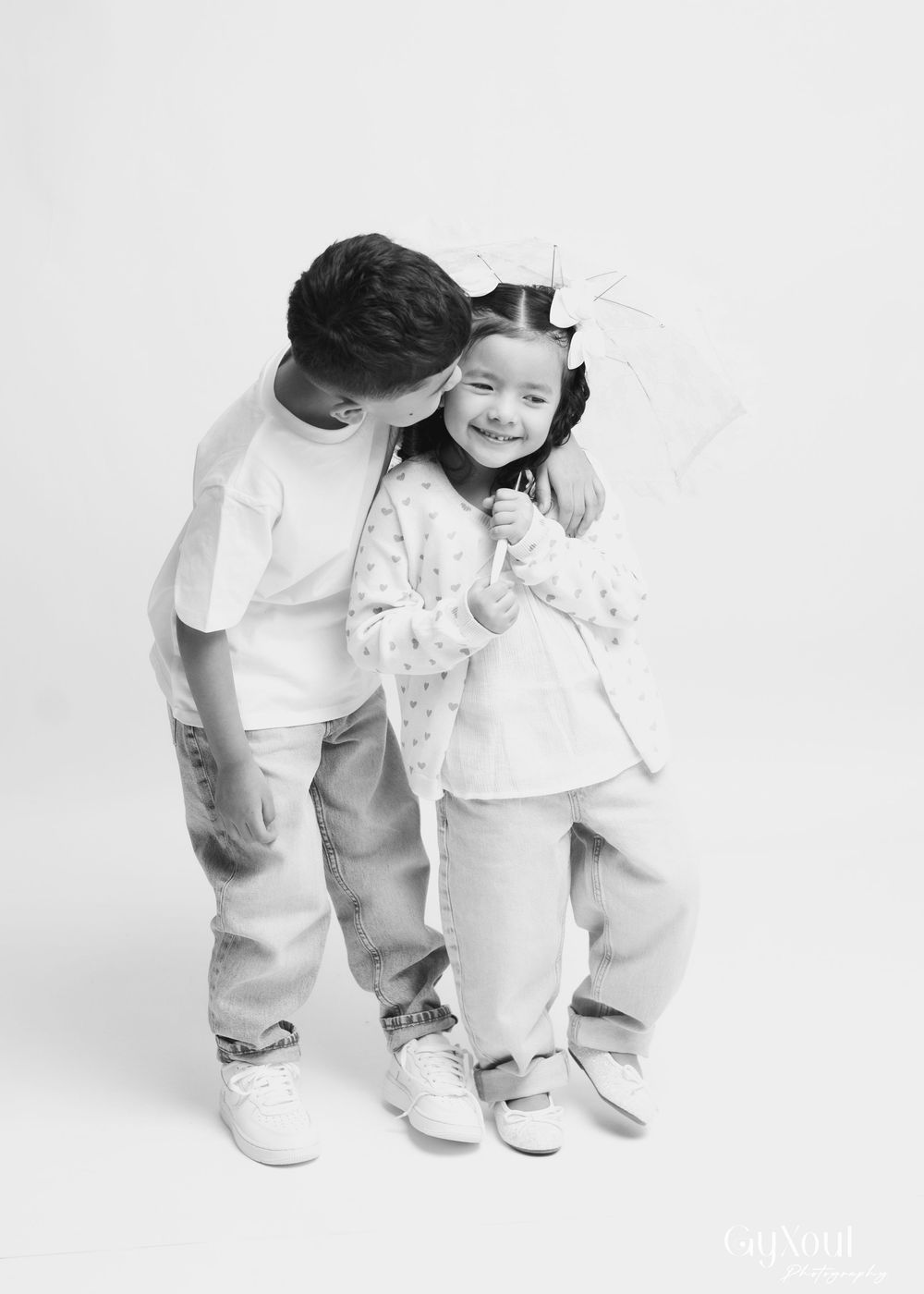 A series of four progressive images showing a child in white clothing bending down in stages against a light background.