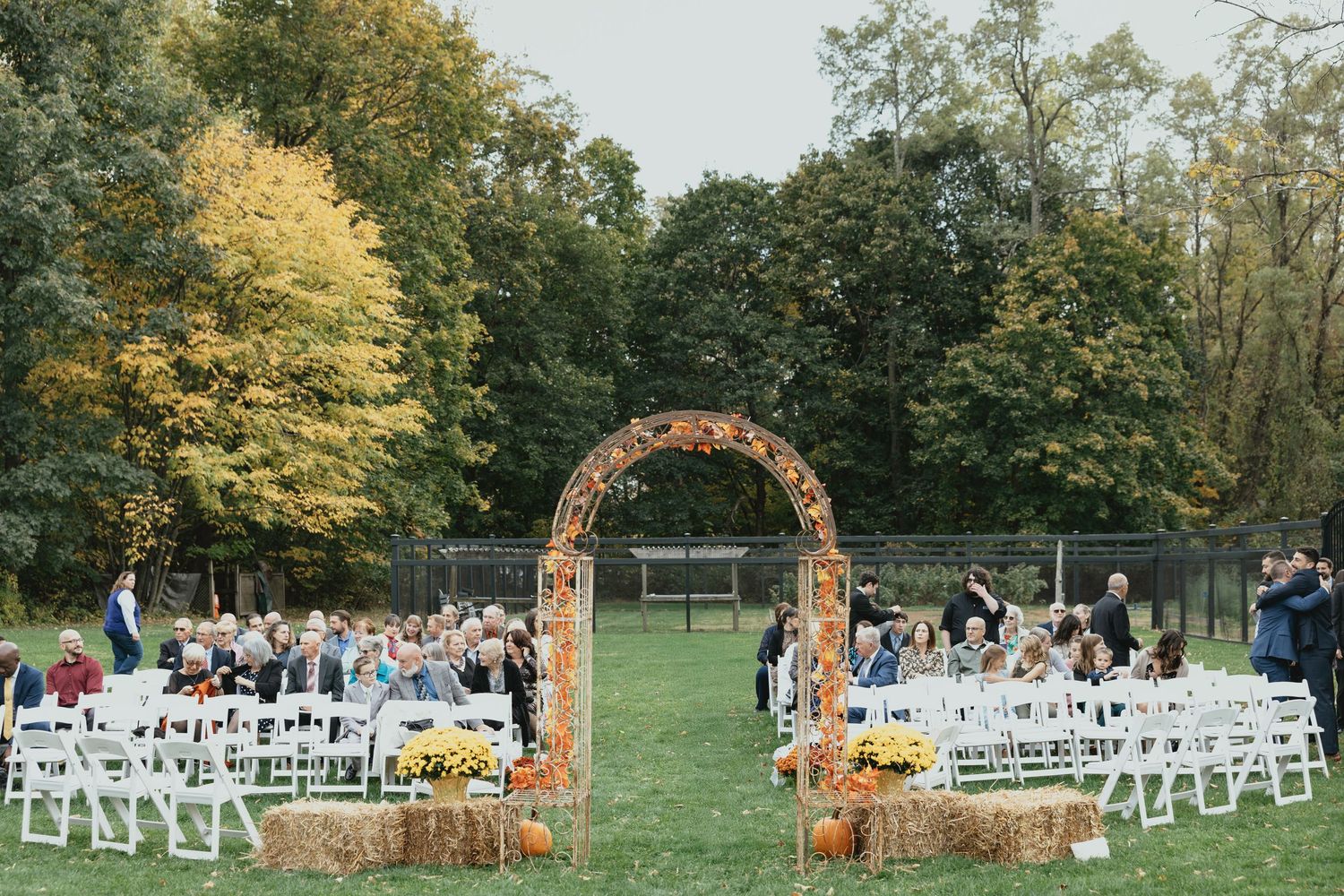Large elegant wedding reception venue with white tables, chiavari chairs and crystal chandeliers set up for a formal event.