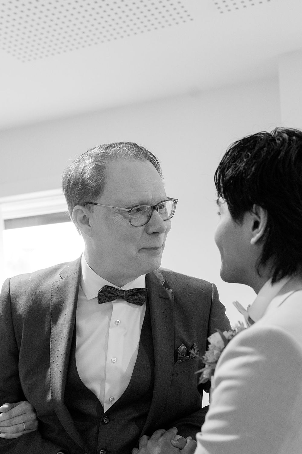 A sequence of black and white photos showing two people in formal attire having an intimate conversation.