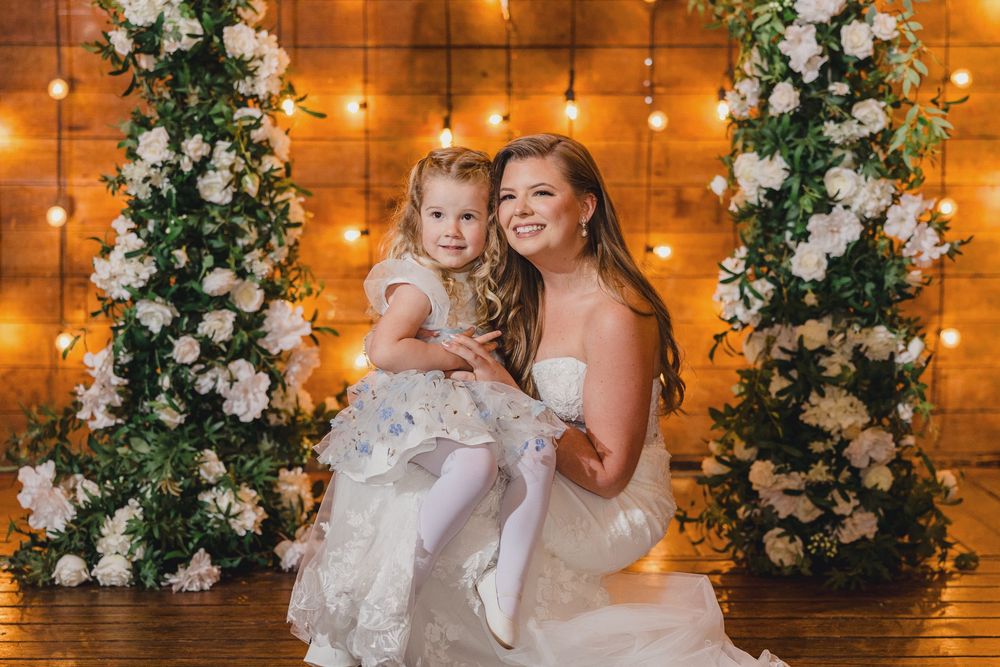 A wedding celebration with white floral arrangements and warm string lights creating an elegant rustic ambiance.