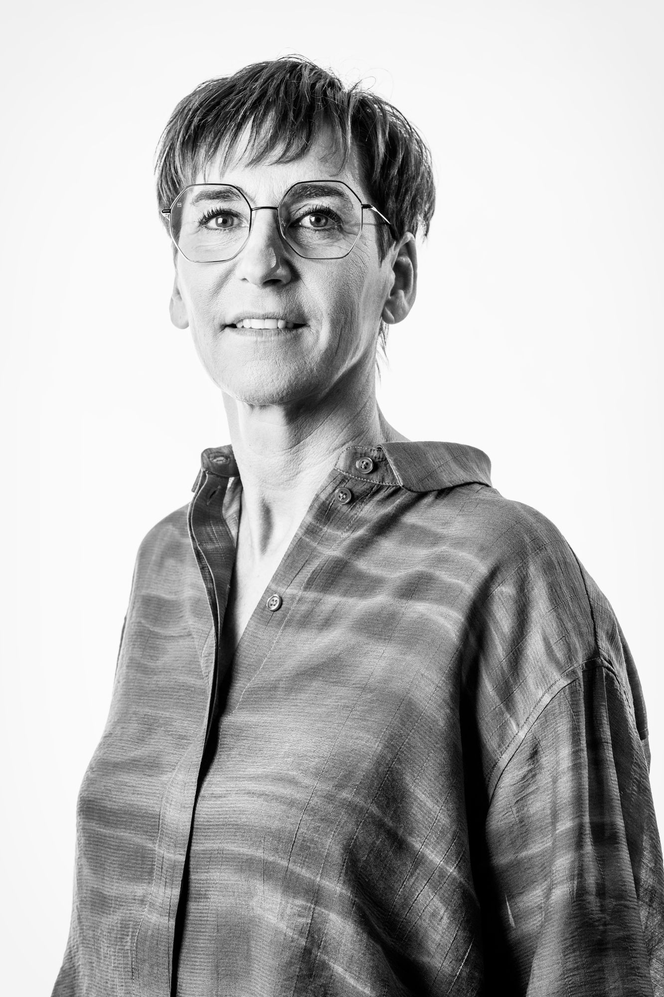 Professioneel LinkedIn portret van vrouwelijke professional met bril, zwart wit studiofoto voor sterke profielfoto op LinkedIn
