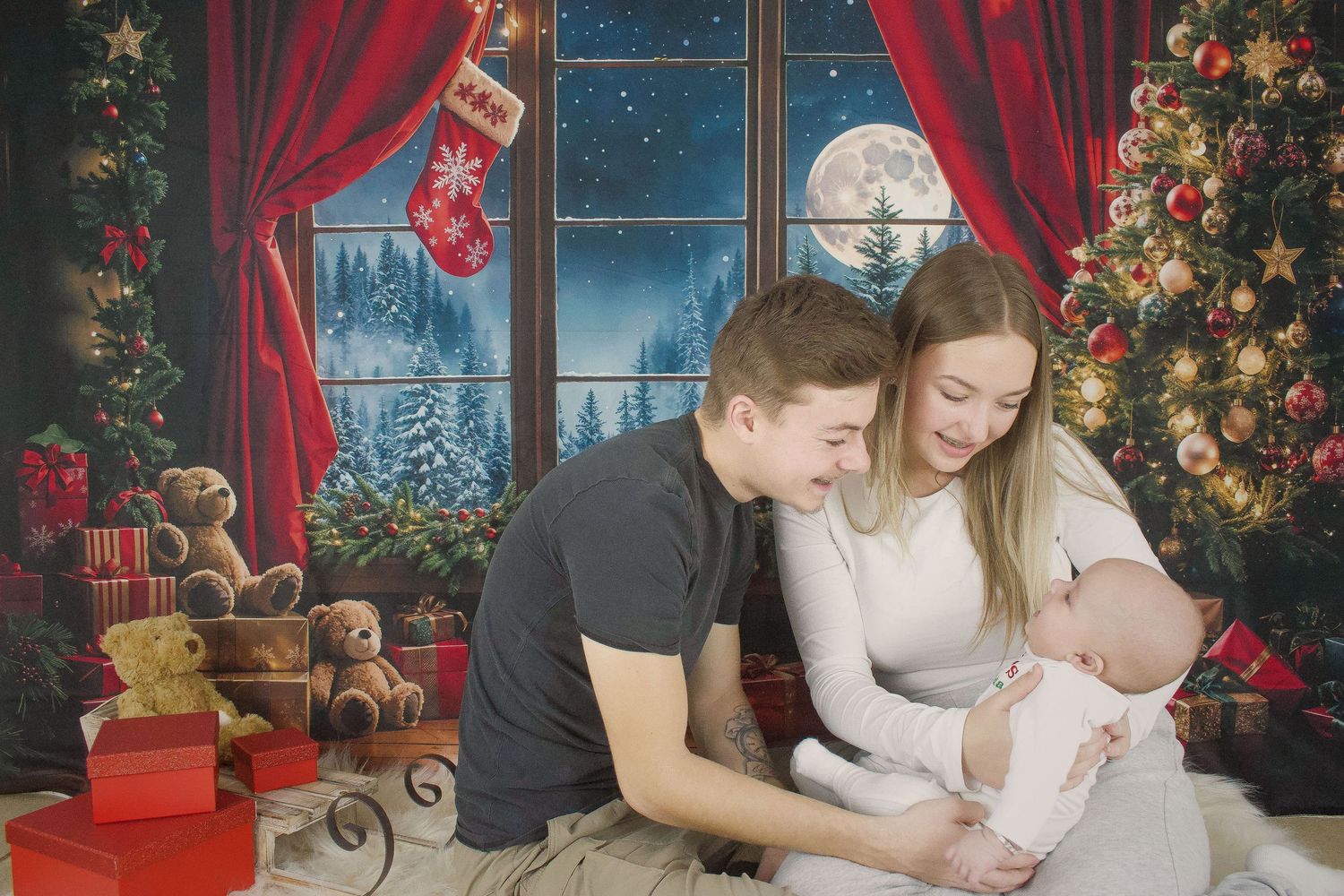 Christmas themed family photoshoot setup with red curtains, decorations and night sky backdrop.