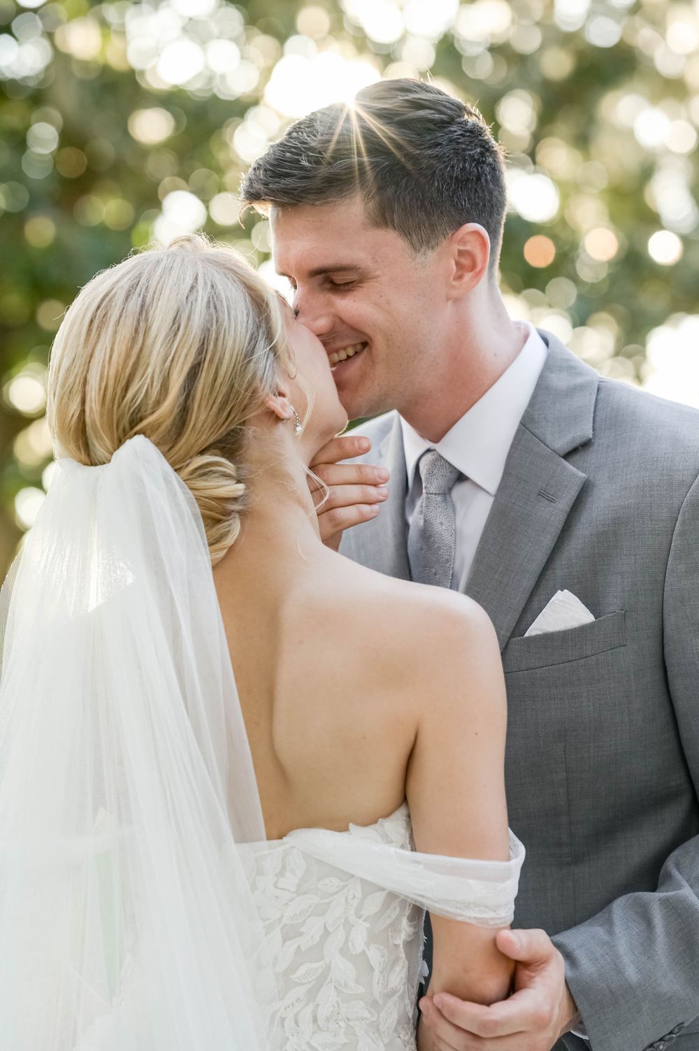 Intimate moment captured with soft bokeh lighting and classic wedding attire.