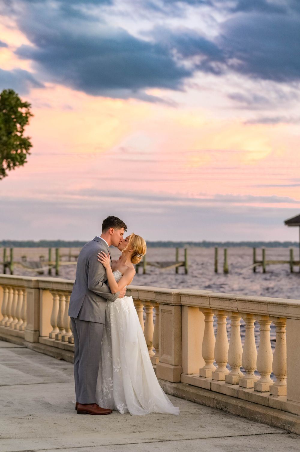 Romantic sunset Weddding portrait on stone balcony overlooking waterfront vista at epping forest