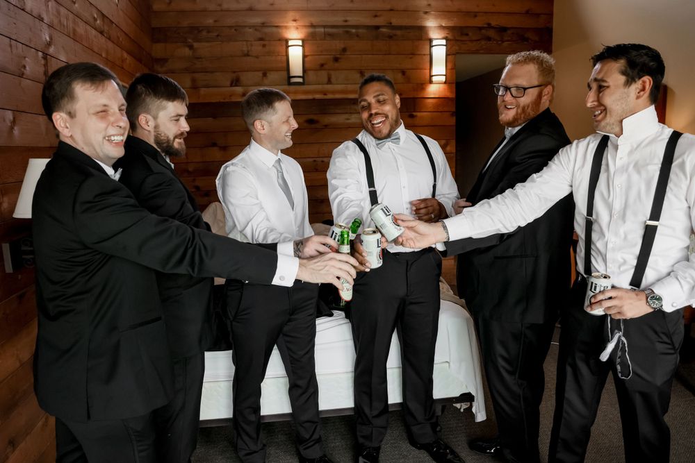 Groomsmen in formal attire sharing a celebratory toast before the wedding ceremony.
