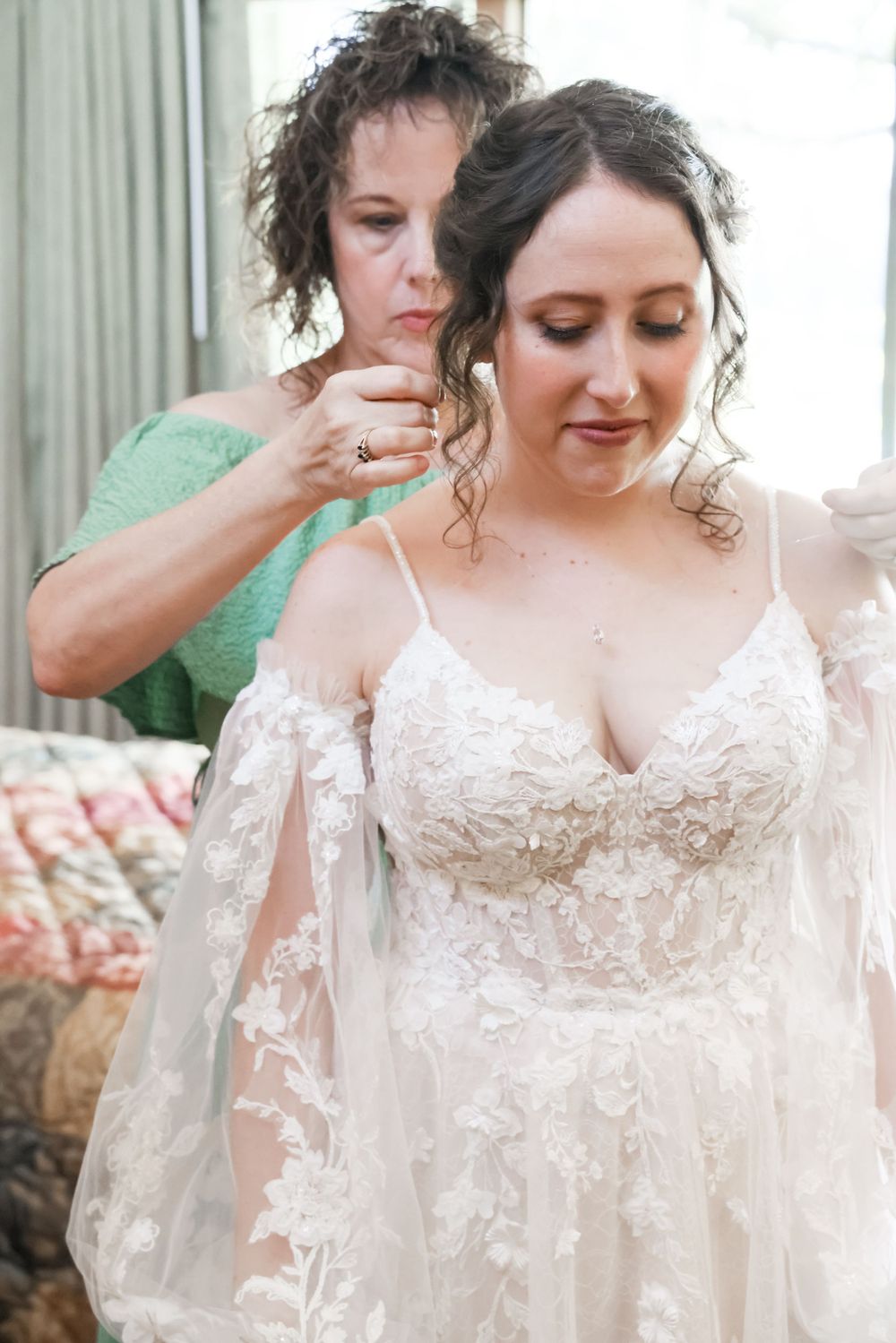 Two people sharing an intimate moment during wedding dress preparations.