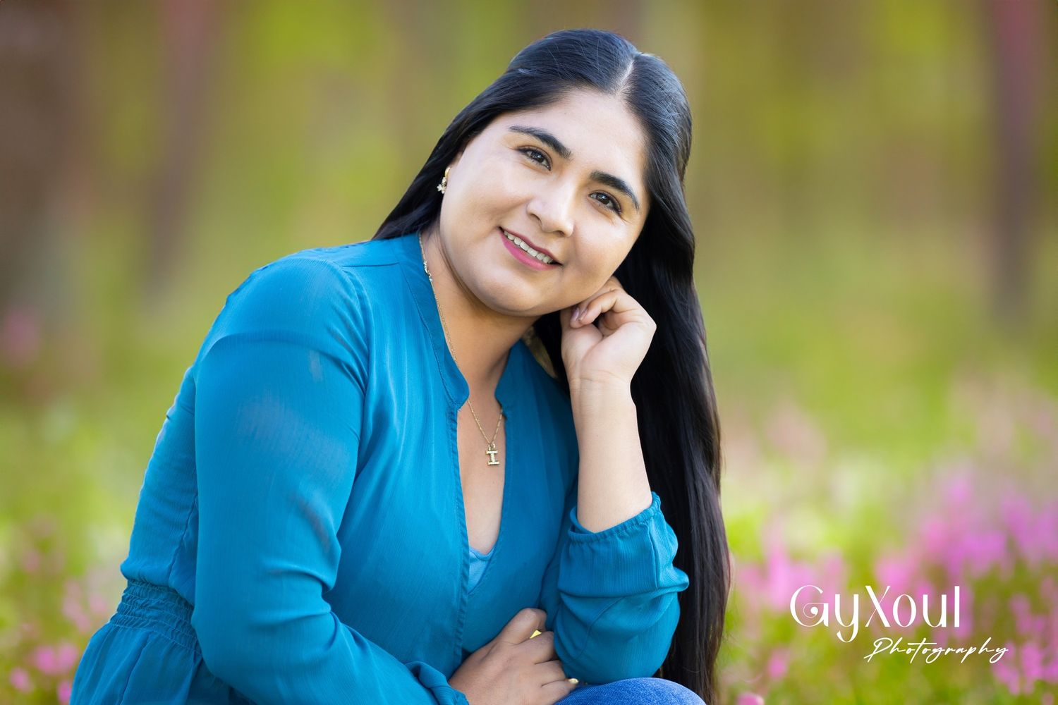 Outdoor portrait in bright blue sweater against blurred nature background.