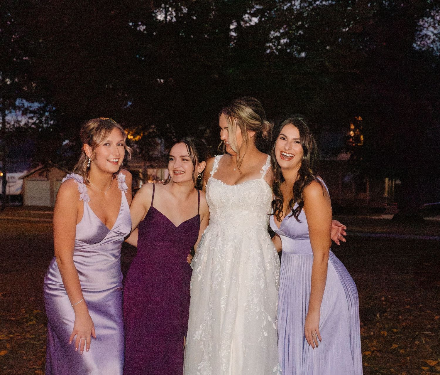 Intimate group photo of wedding party members in coordinated evening attire.
