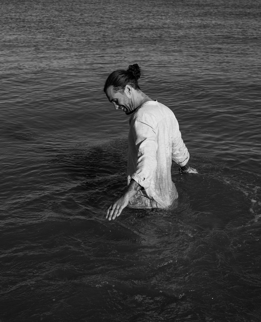 Dramatic black and white photo of someone submerged in dark water.