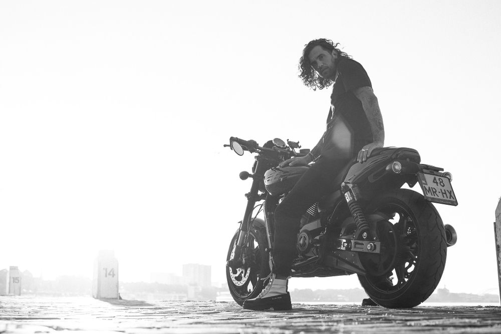 Silhouetted motorcycle rider against bright misty background.