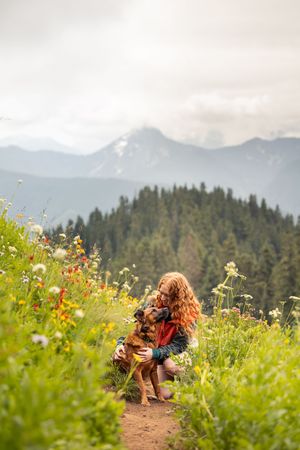 Dog and owner photographed outdoors with mountain backdrop