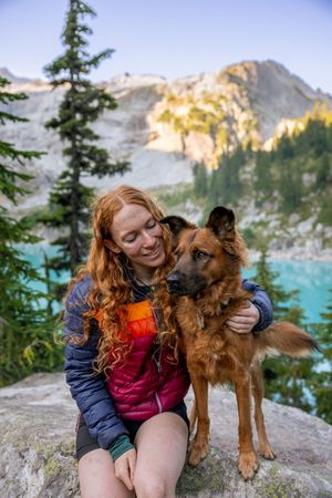 Dog and owner photographed outdoors with mountain backdrop