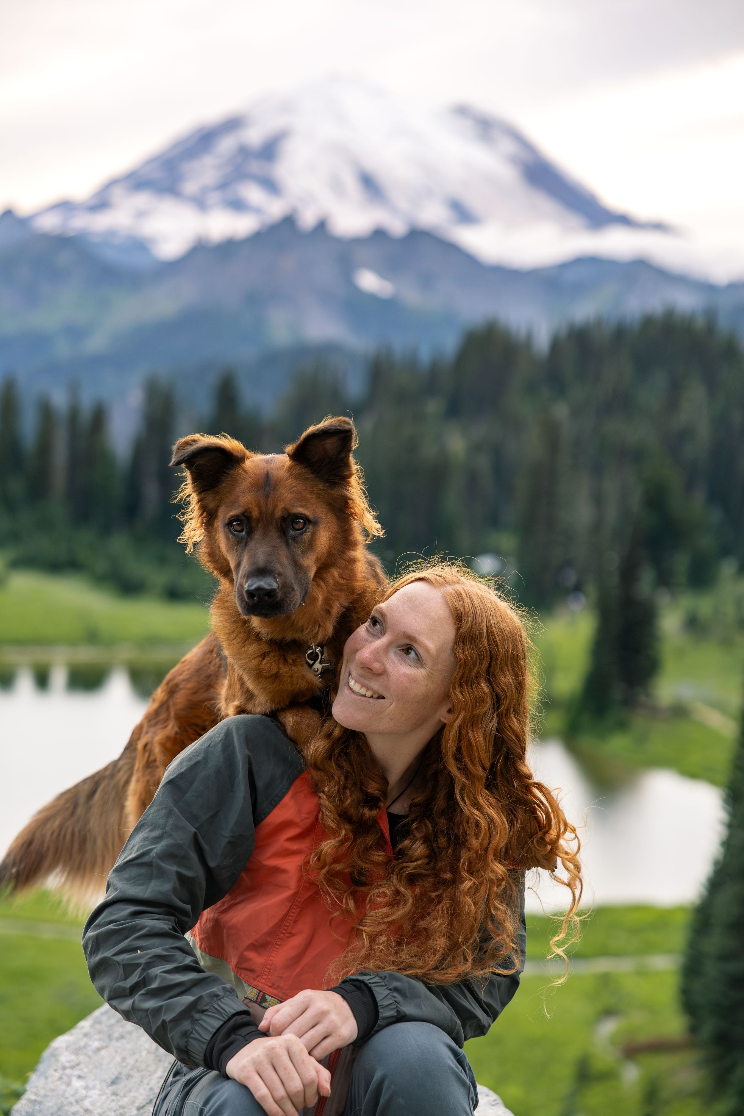 Dog and owner photographed outdoors with mountain backdrop