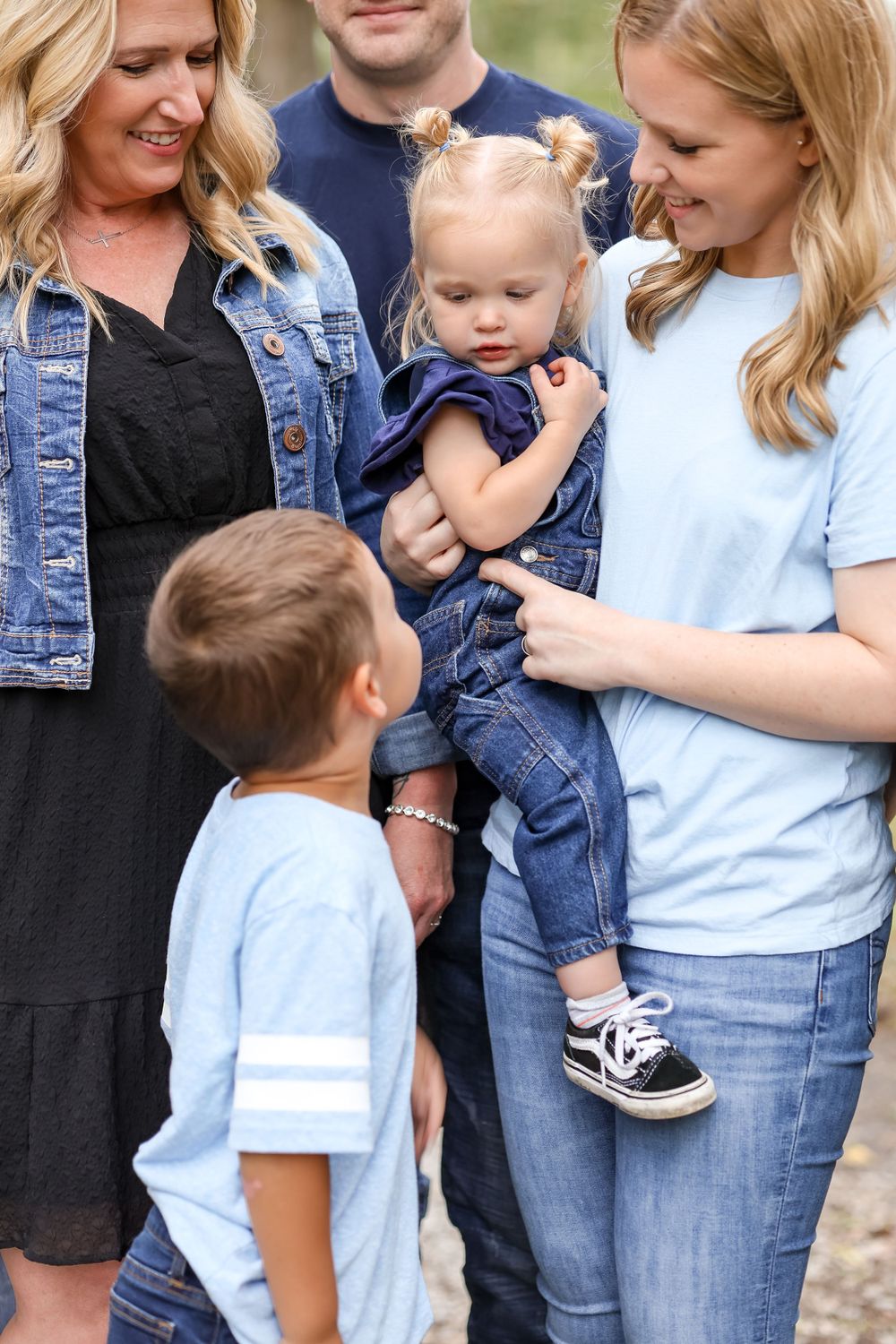 Close up of two kids interacting together amongst a group of people