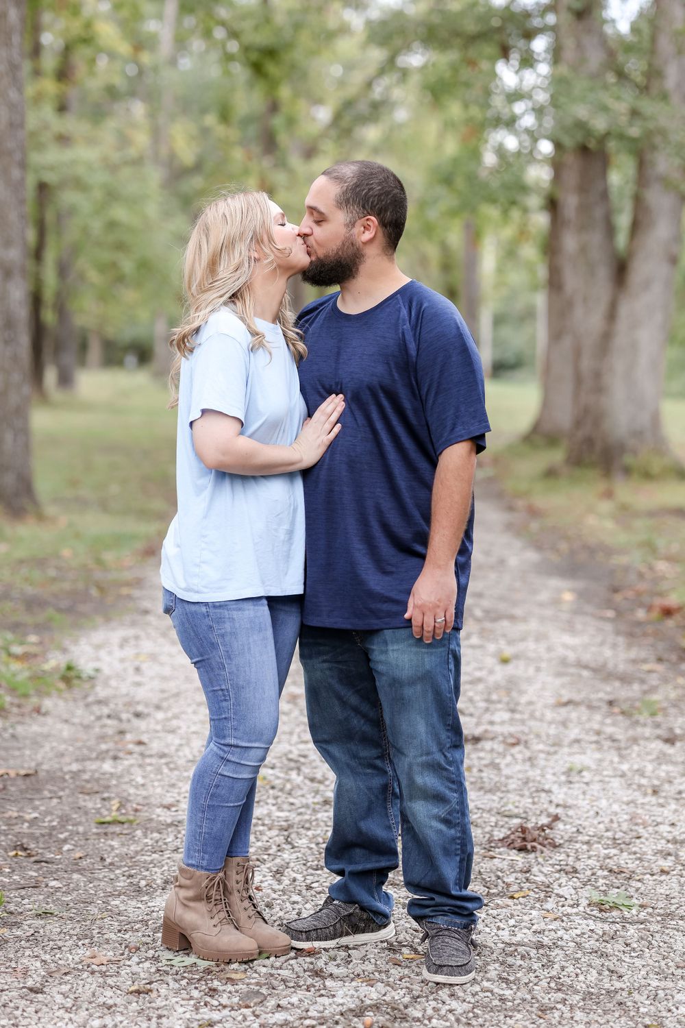 Couple kiss on a trail lined by trees in Springfield, IL