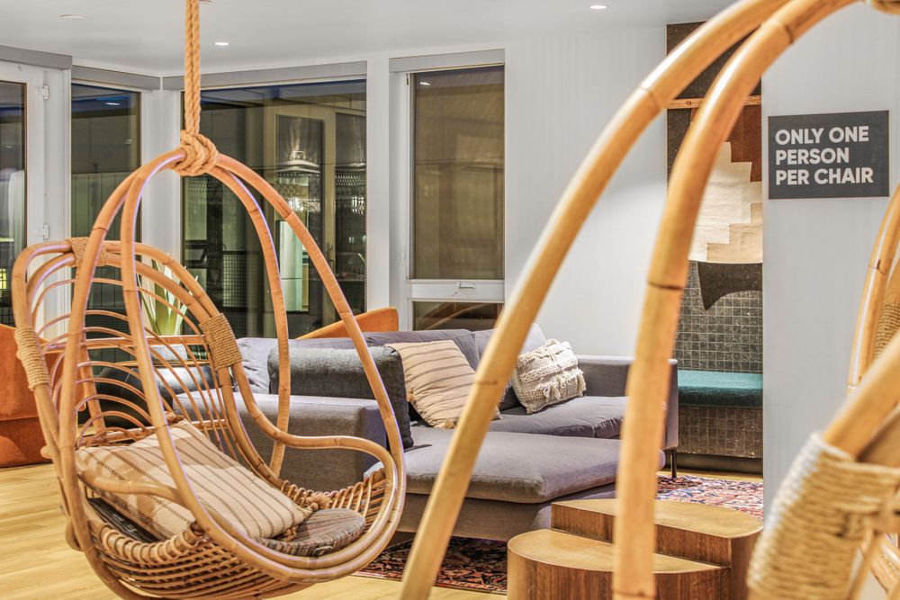 Cozy lounge area with hanging rattan egg chairs and comfortable seating arrangements.