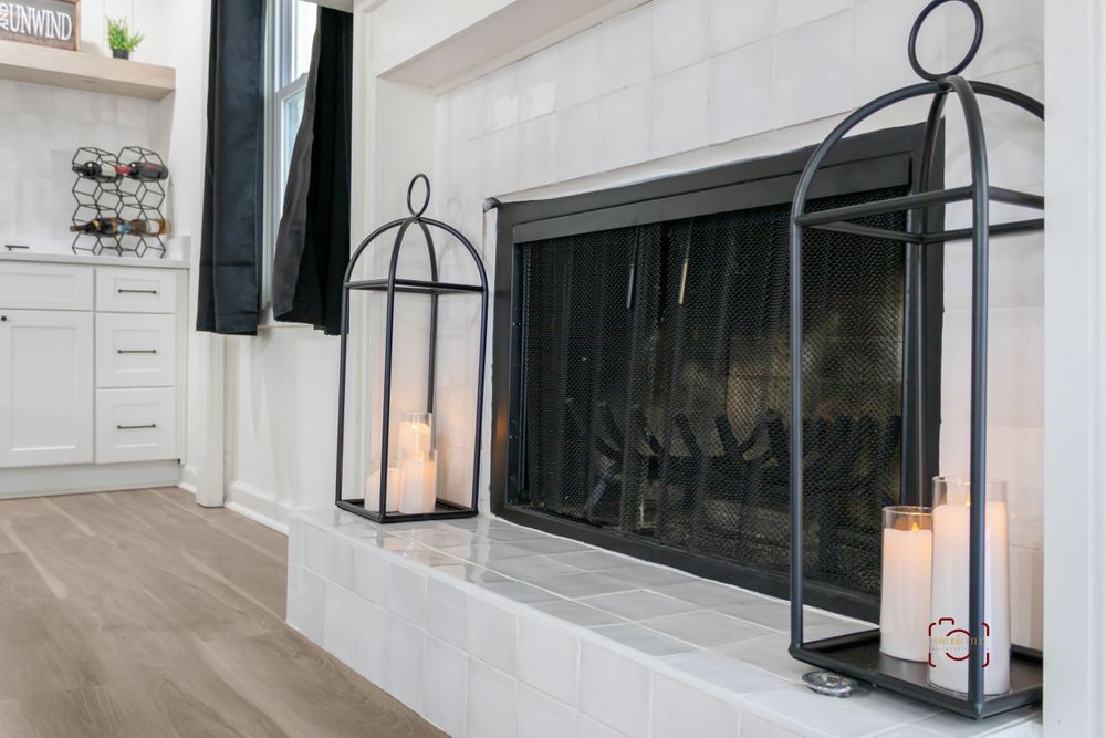 Modern white fireplace with glass doors and black metal lantern decorations on either side.