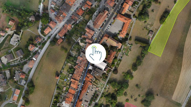 Aerial view of residential houses with pointer icon indicating specific location.