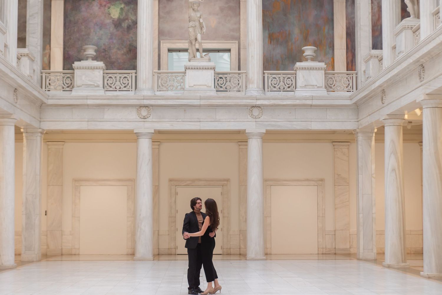 An elegant ballroom interior with white columns and decorative architectural details.