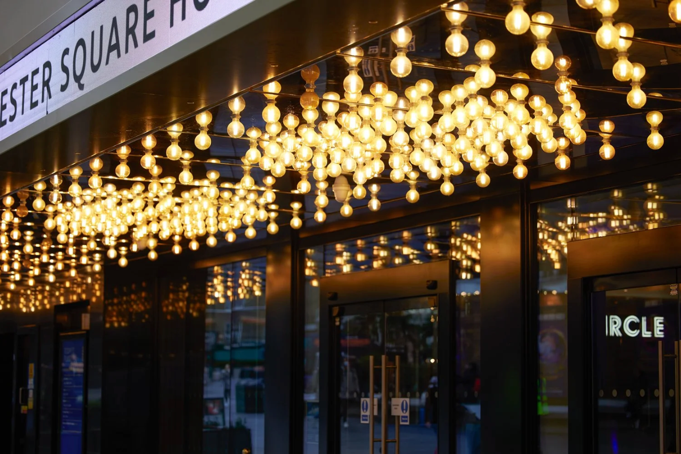 Decorative string lights illuminate a dark ceiling creating a warm glowing ambiance in an indoor space.