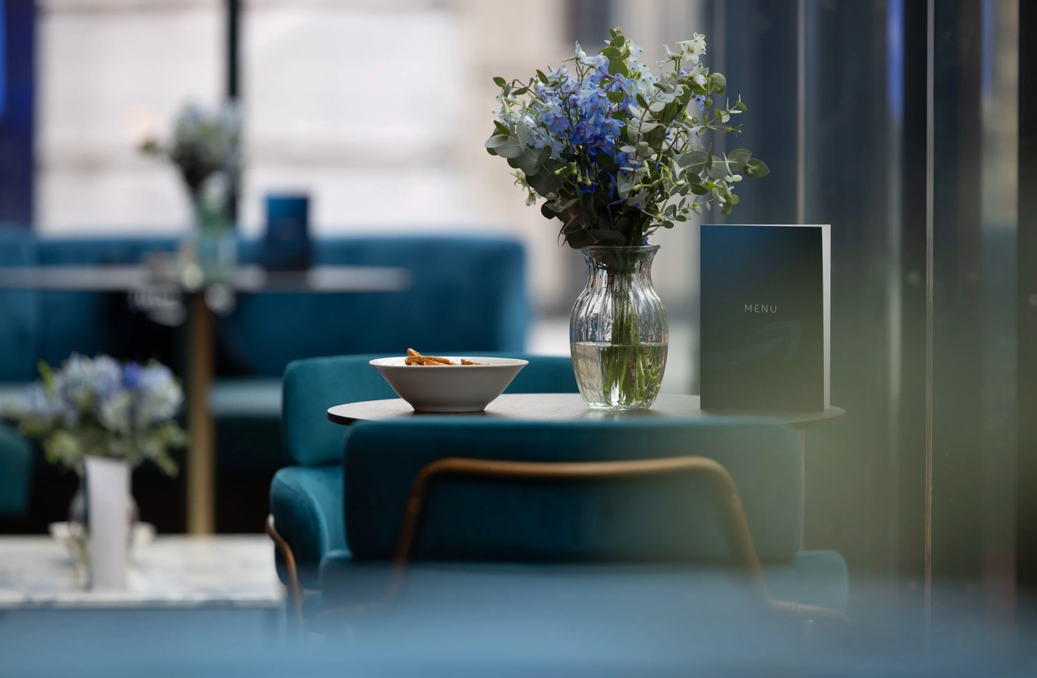 Modern office interior with blue furniture and glass partitions in a minimalist corporate setting.