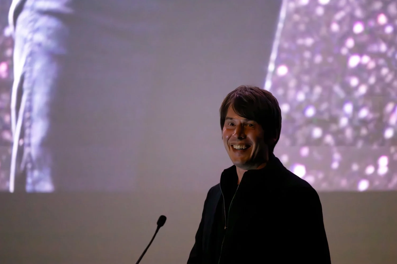 A collage of seven photos showing someone speaking at a podium with a projected display in the background.