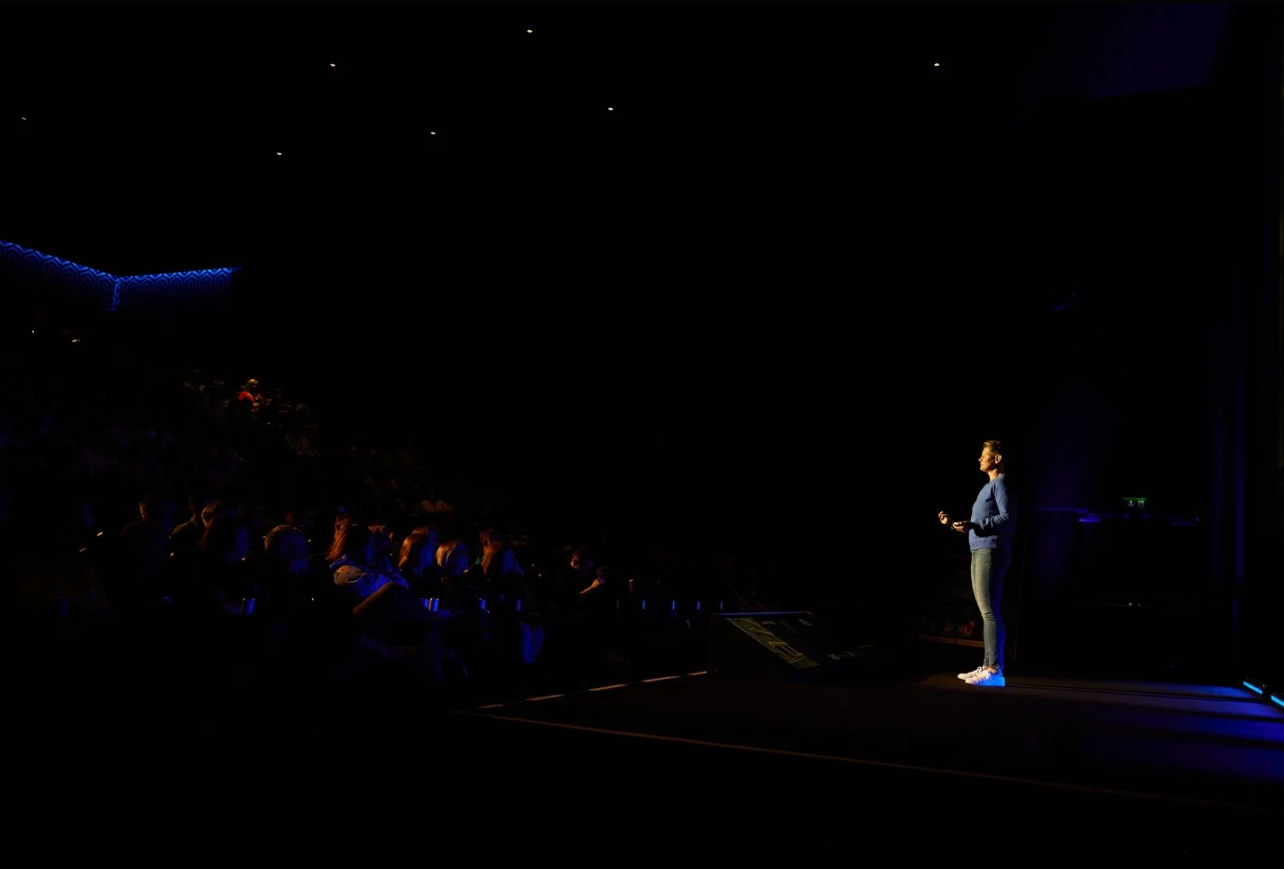 Silhouetted performers on a dark stage with dramatic blue lighting effects.