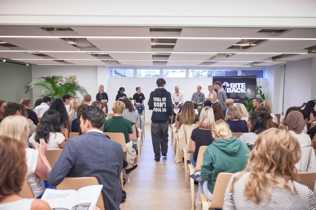 A group of people gathered in a bright office space for a business meeting or workshop session.