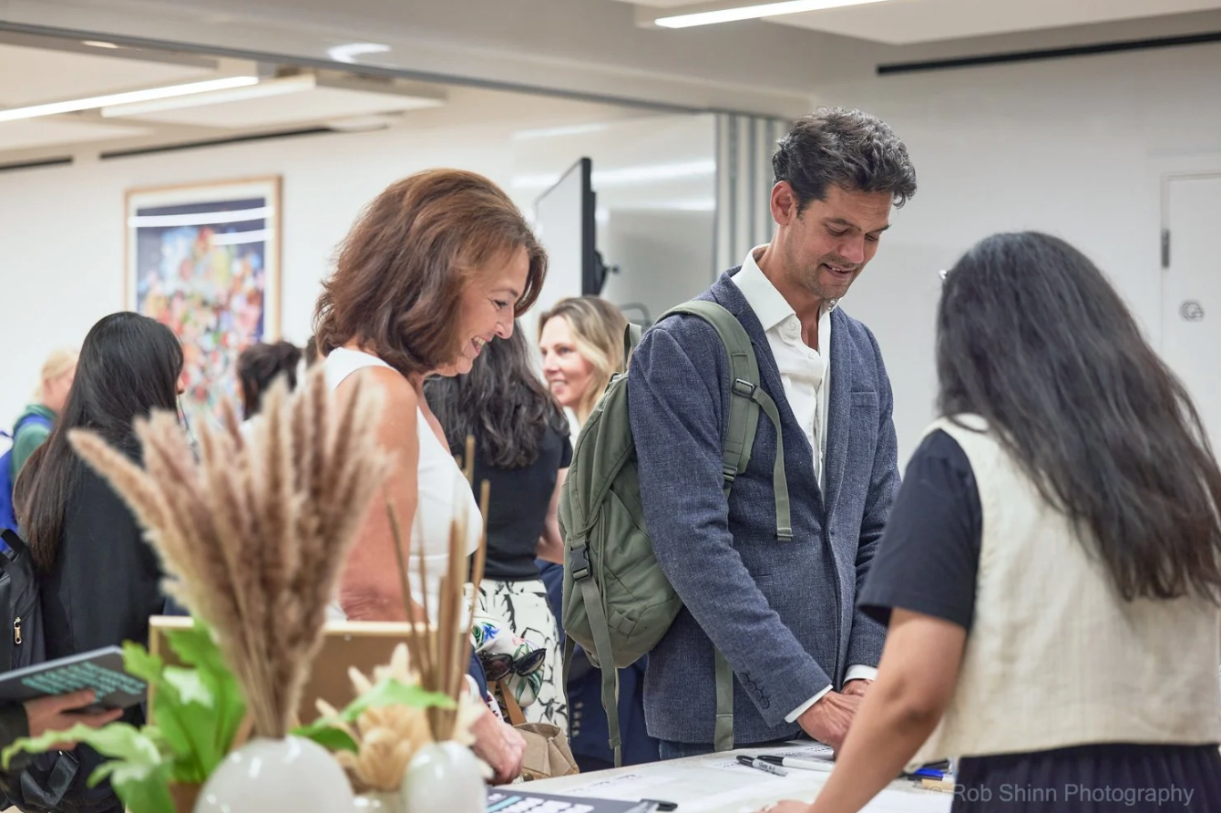 Business professionals network and engage in conversation at a crowded corporate event.