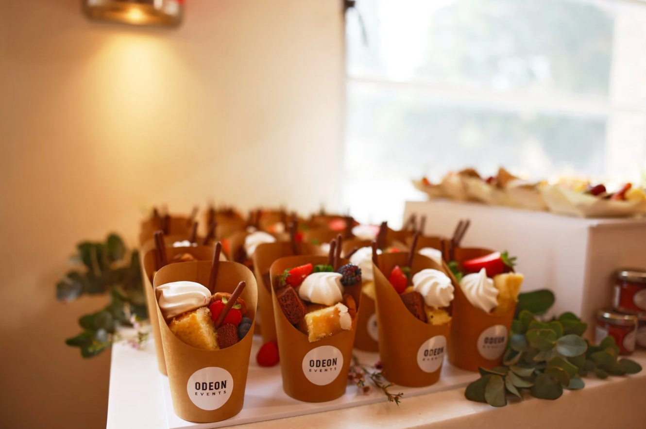 Warm glowing glass candle holders with tea lights arranged in a row on a white surface create an intimate ambiance.