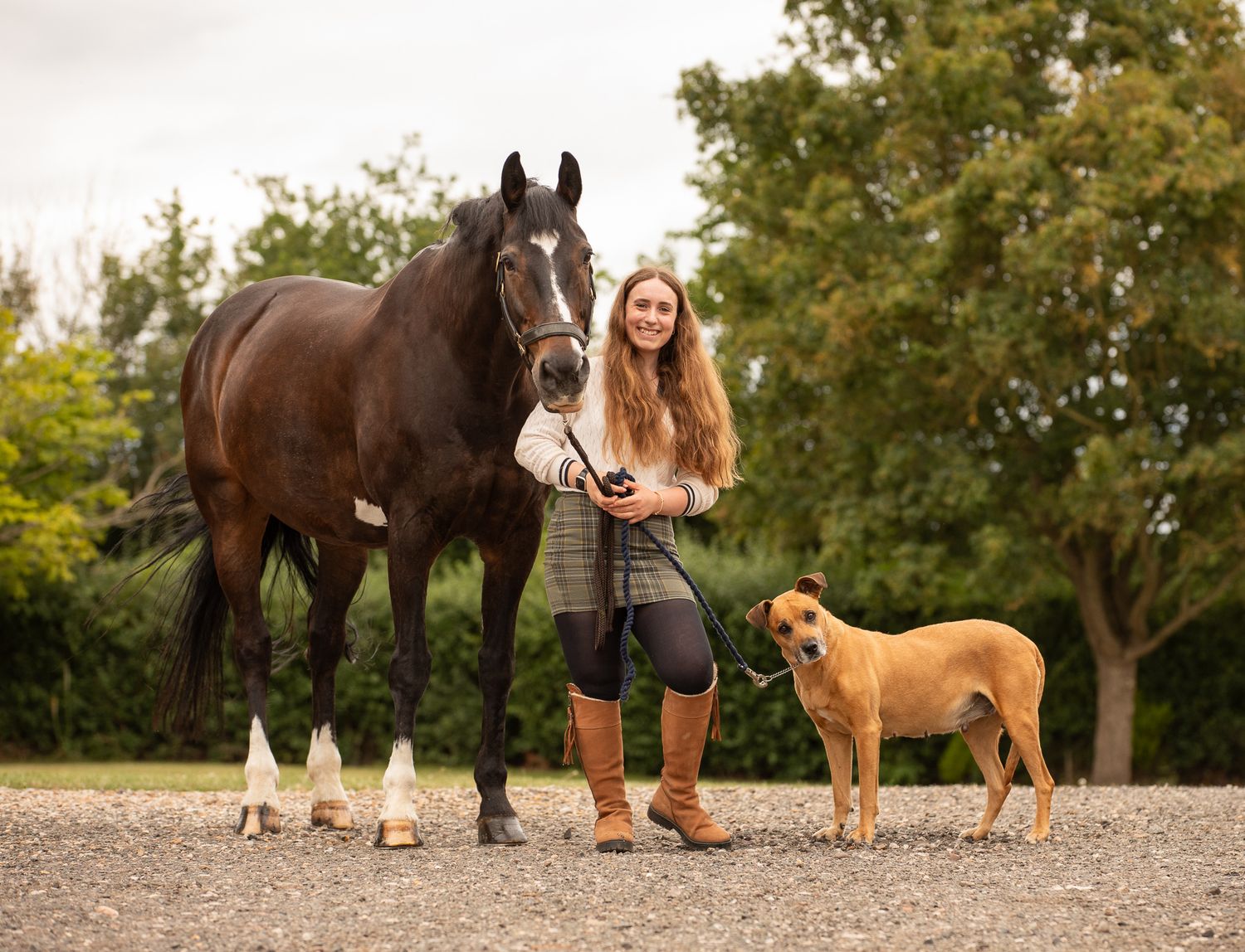 Two joyful riders lean over a white horse's back in a sun-drenched field at golden hour.