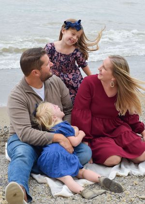 Couple sitting on beach blanket sharing romantic moments in a series of candid photos by the ocean.