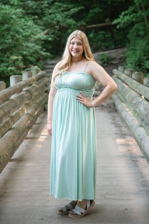 A sequence of photos showing someone in a mint green summer dress posing on a wooden bridge in a forest setting.