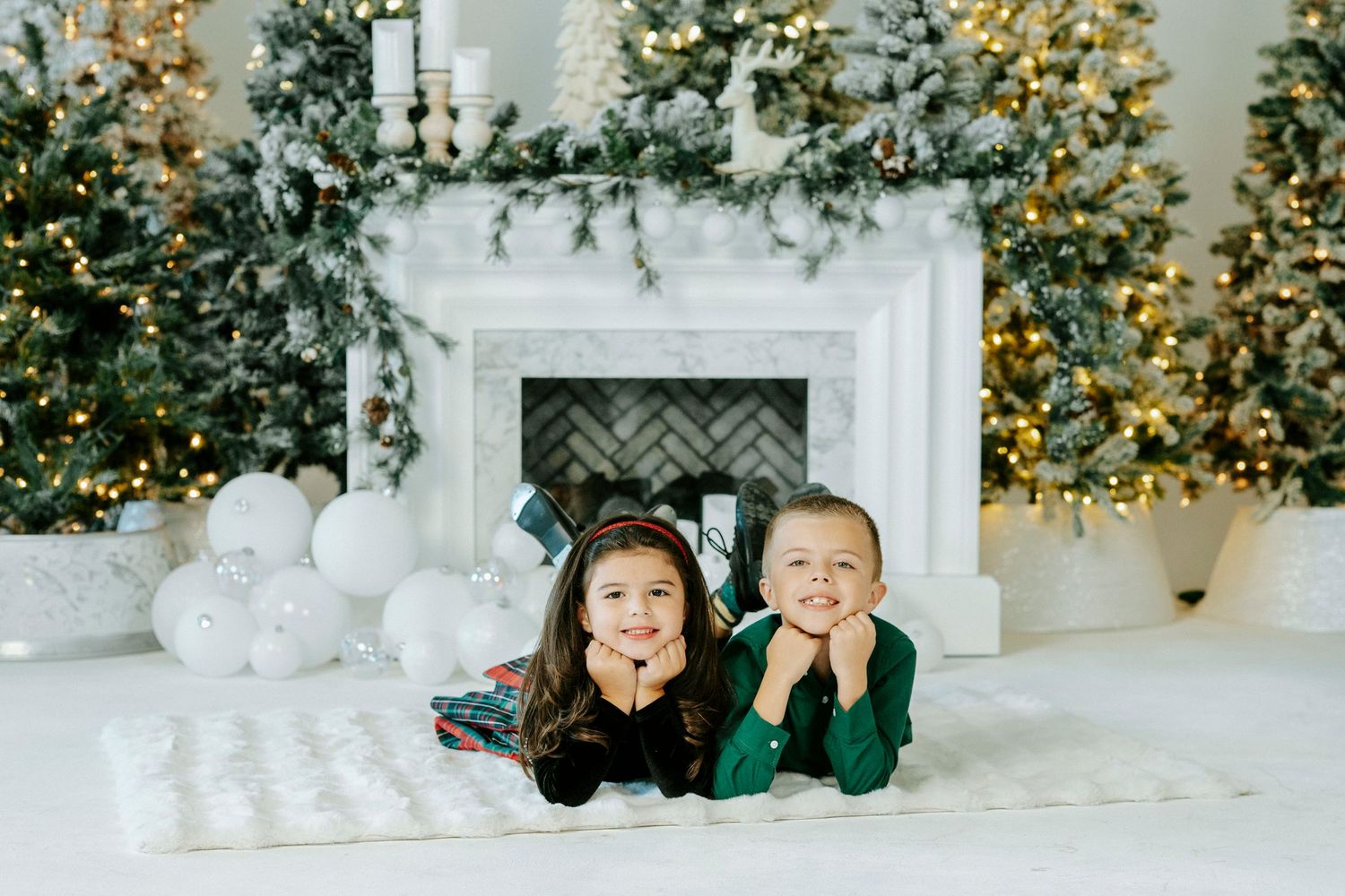 A festive holiday scene with decorated Christmas trees and white decor in an elegant room setting.