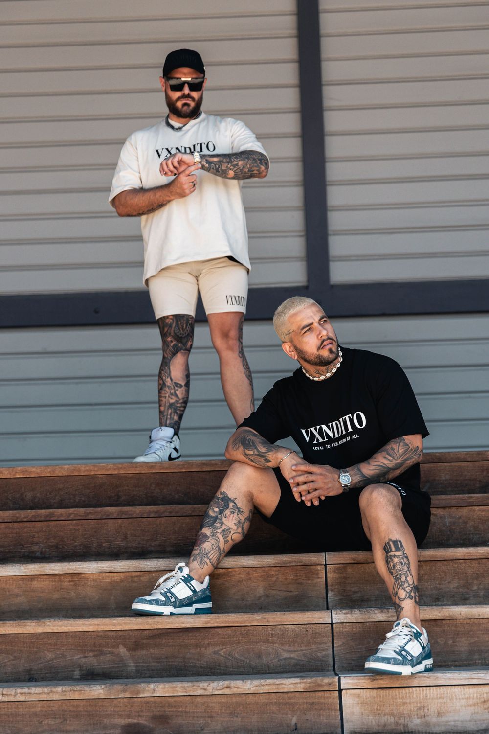 Casual streetwear fashion shoot on wooden steps with tattooed models.