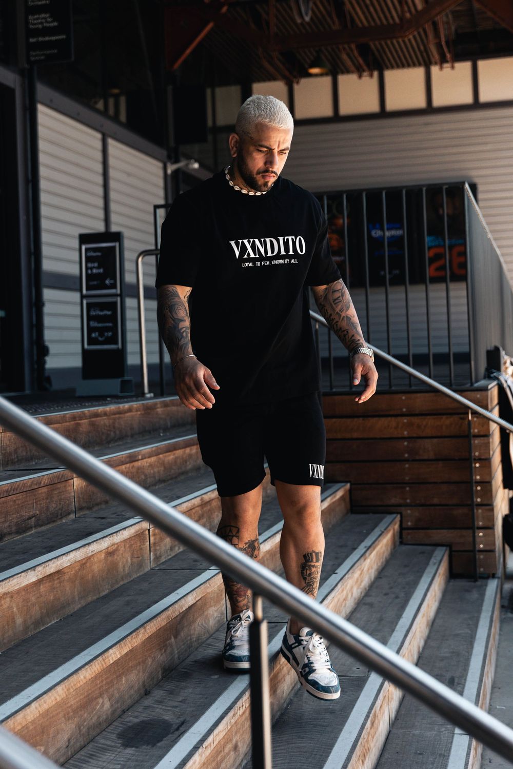 Urban photoshoot on wooden bleachers showing streetwear fashion details.
