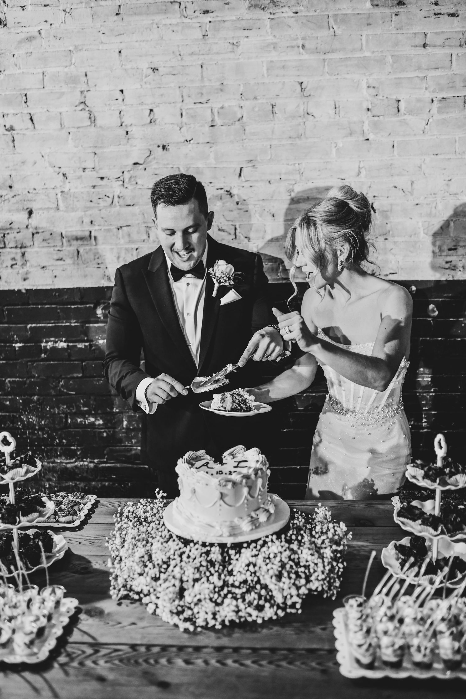 Bride and groom share candid moment cutting cake at Brake and Clutch.