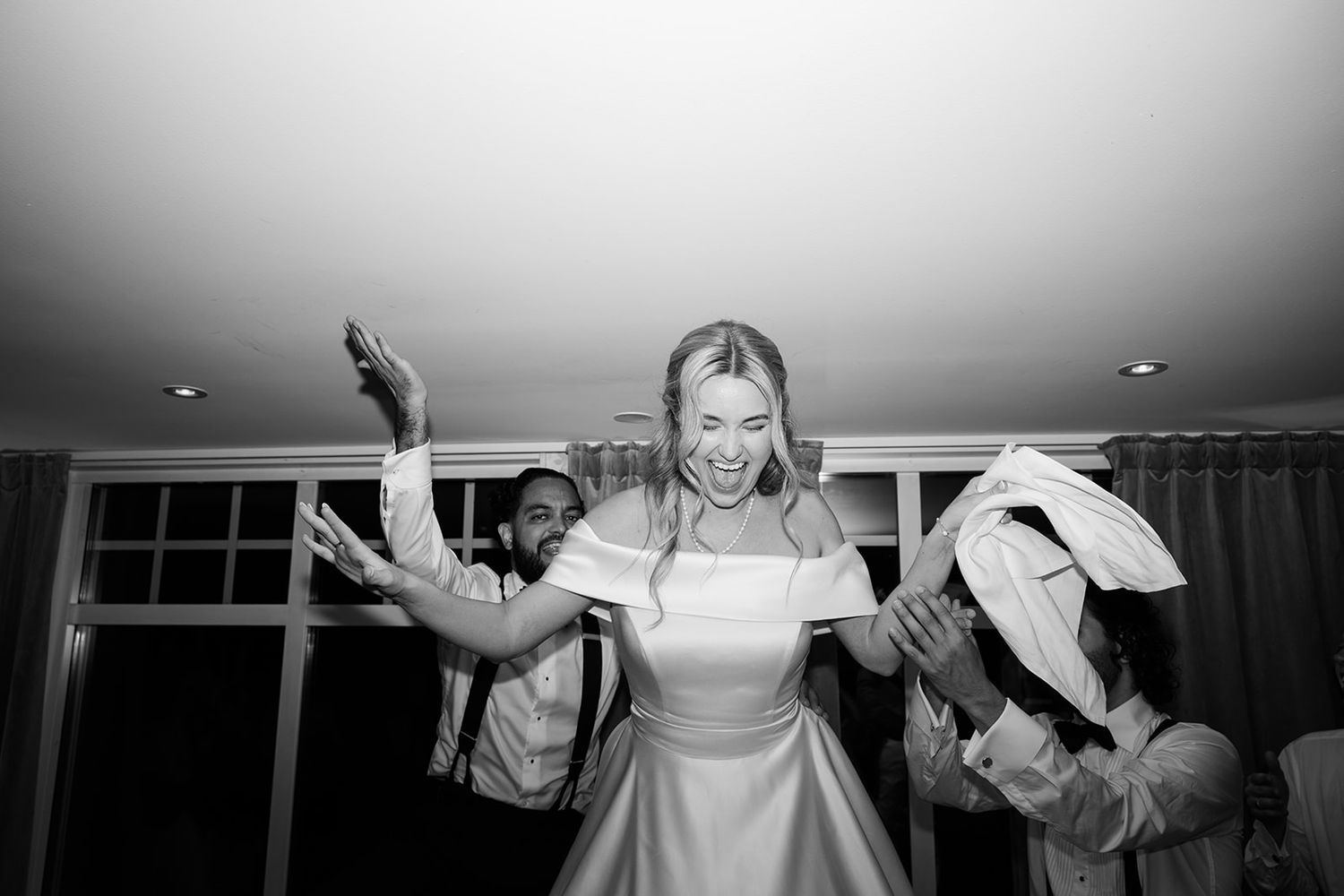 A series of black and white photos showing a person joyfully posing and dancing in different positions.