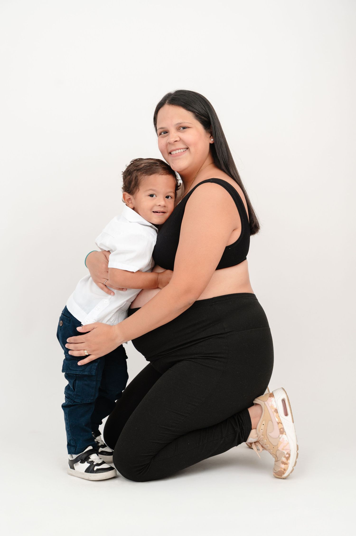 A sequence of three tender moments showing a person in black embracing a small child against a white background.