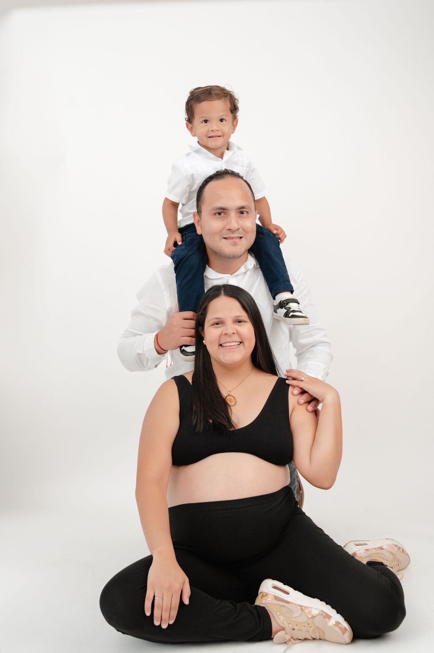 A mother and child pose together in a series of playful portraits against a white background wearing black and white outfits.