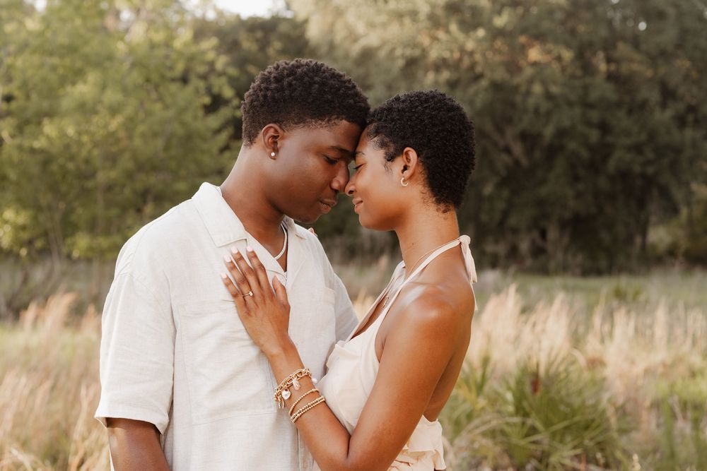 A romantic couple shares tender moments in a golden-lit outdoor setting during a photo session.