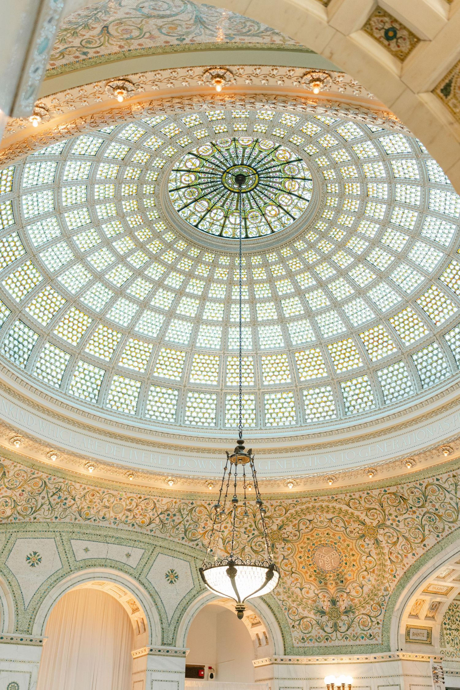Ornate glass dome ceiling with intricate architectural details and decorative patterns in the Chicago Cultural Center.
